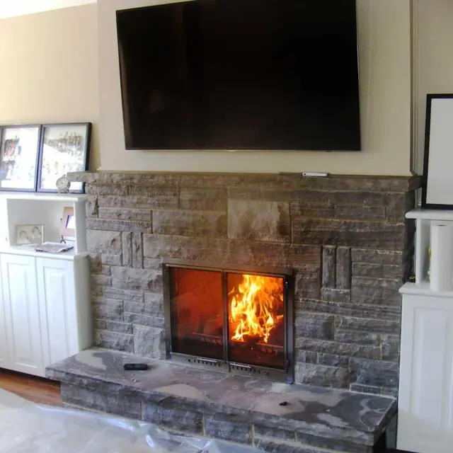 A new stone fireplace with a fire burning