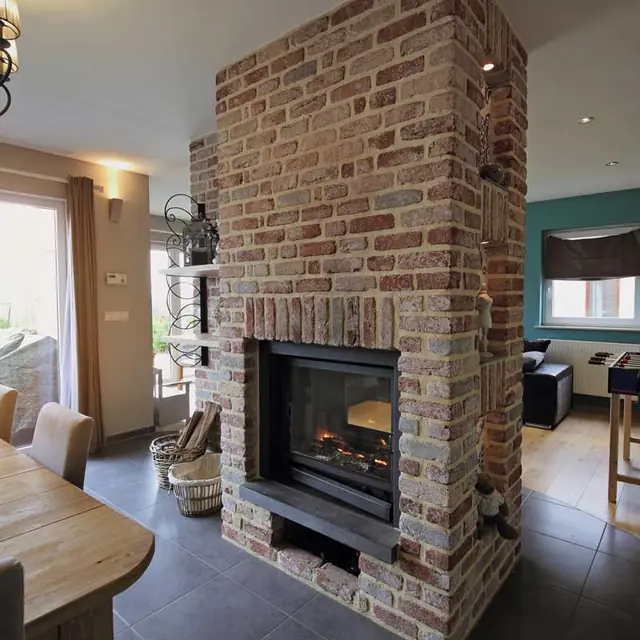 A brick fireplace in a bright living room